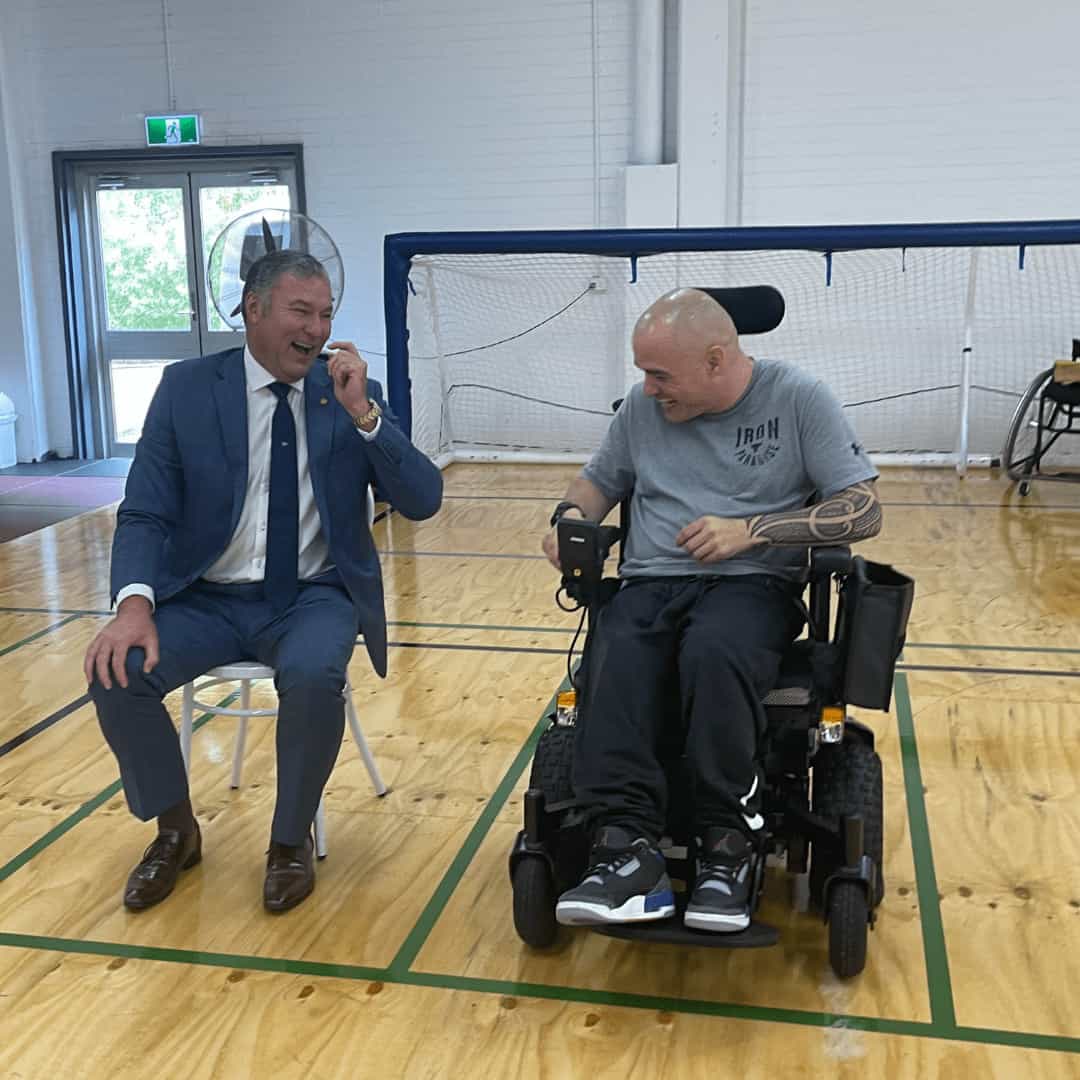 Sporting Wheelies Game Changer chats to male board member on the court at Brisbane gym.