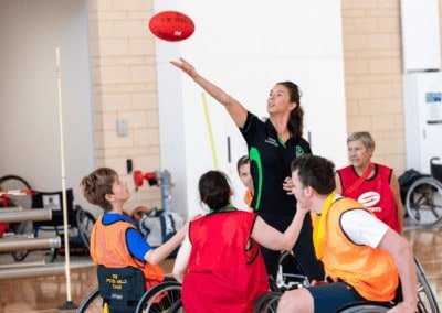 Sporting Wheelies Game Changer throws ball up in the air in a game of wheelchair AFL.