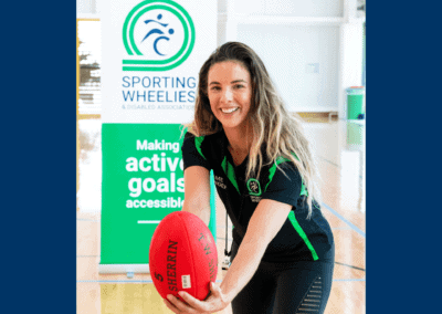 Female Game Changer demonstrates wheelchair AFL skills by passing the ball.