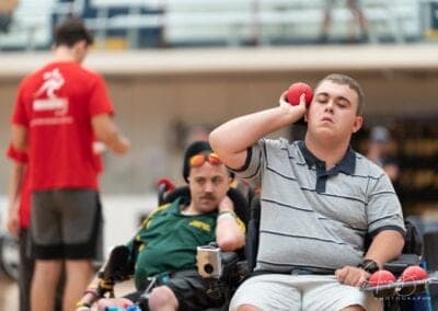 A male boccia player aims to throw the ball in a game of boccia.
