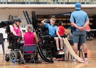 In a game of boccia, two players in wheelchairs prepare to have their turn in throwing the ball.