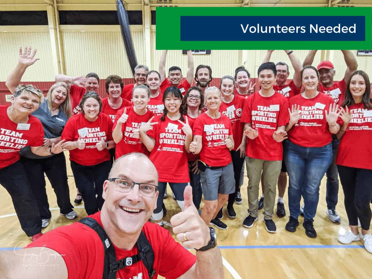 A group of Sporting Wheelies volunteers coming together for a photo.