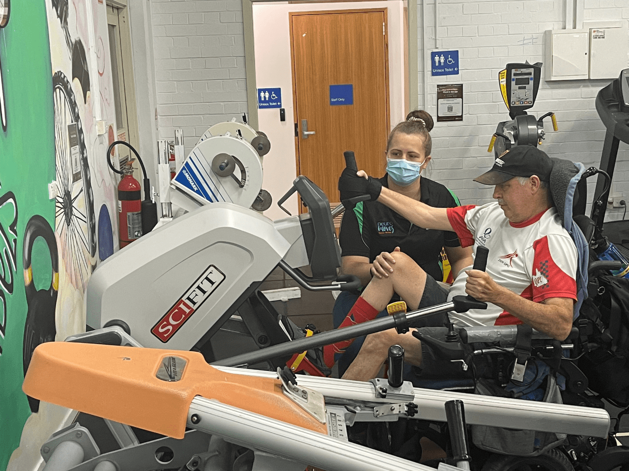 With the help of trainers, a young female client completes exercise physiology on a treadmill.