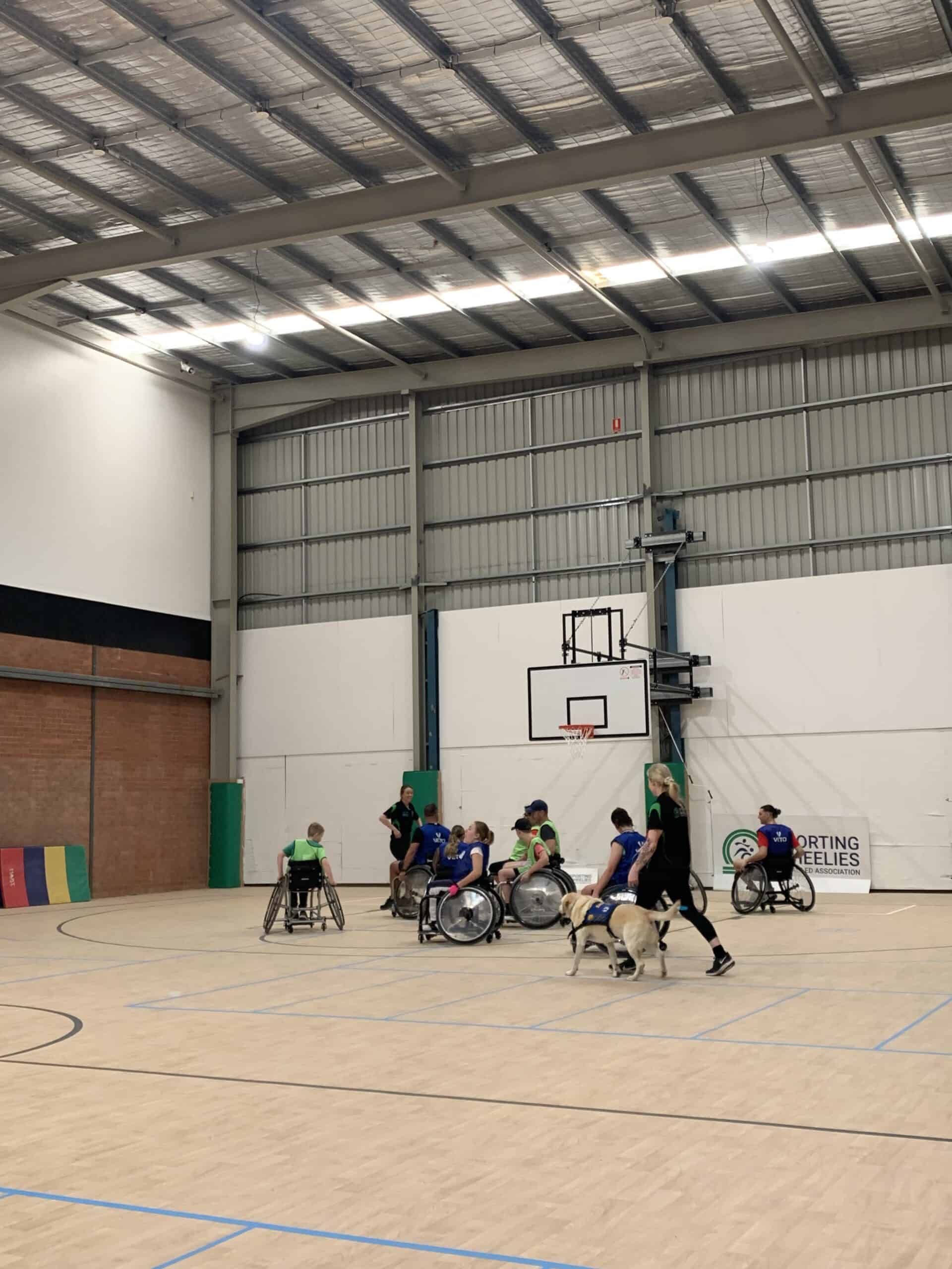 Render of the potential site for Milton showing people playing Wheelchair Basketball with Goalball courts and Gym in the background