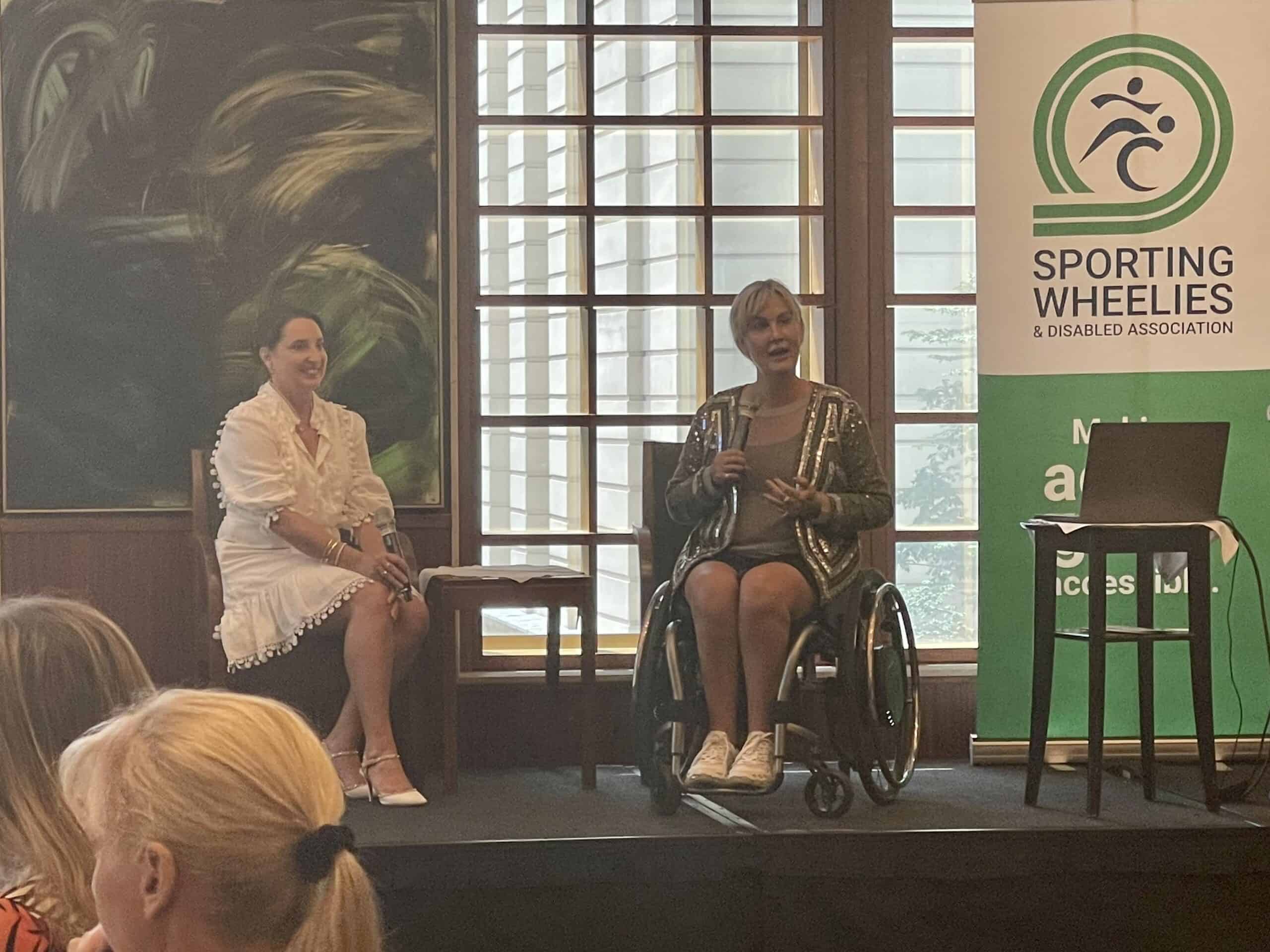 Sporting Wheelies CEO Amanda sits with a female guest speaker at an event.