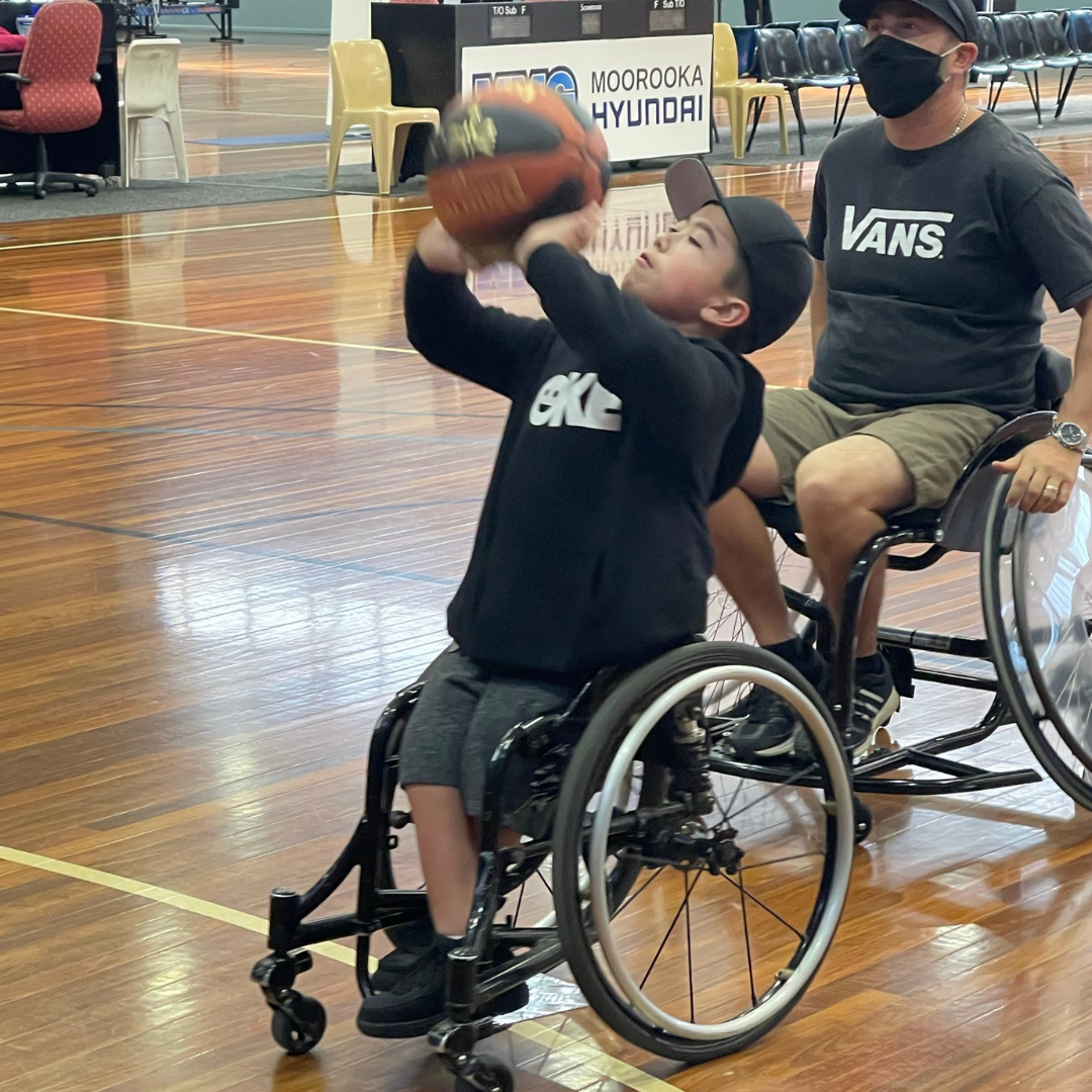 Josh A young girl plays wheelchair basketball on the court.