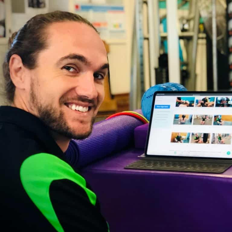 Male employee completing exercise physiology work on his computer at Sporting Wheelies gym.