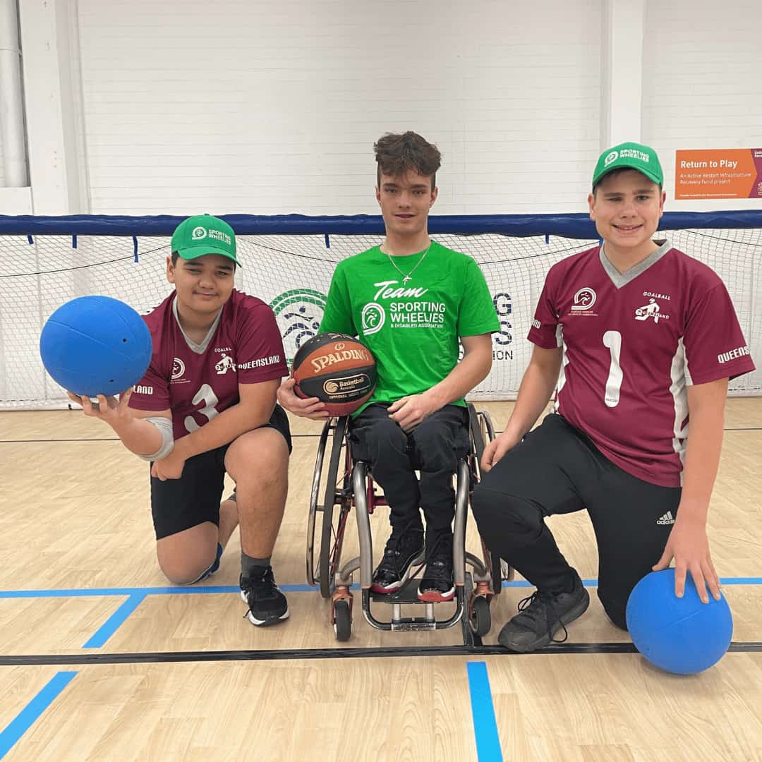 Wheelchair basketball plater and two goal ball players come together for a photo.