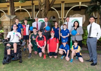 Sporting Wheelies members come together with different school students and teachers for a group photo.