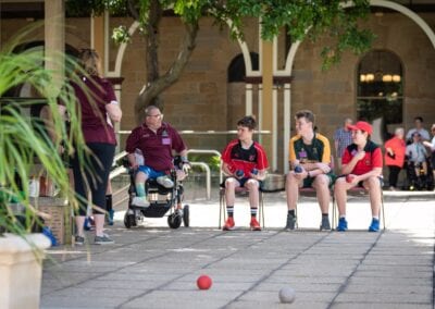 Sporting Wheelies member chats to schoolboys during a game of boccia at a school visit.