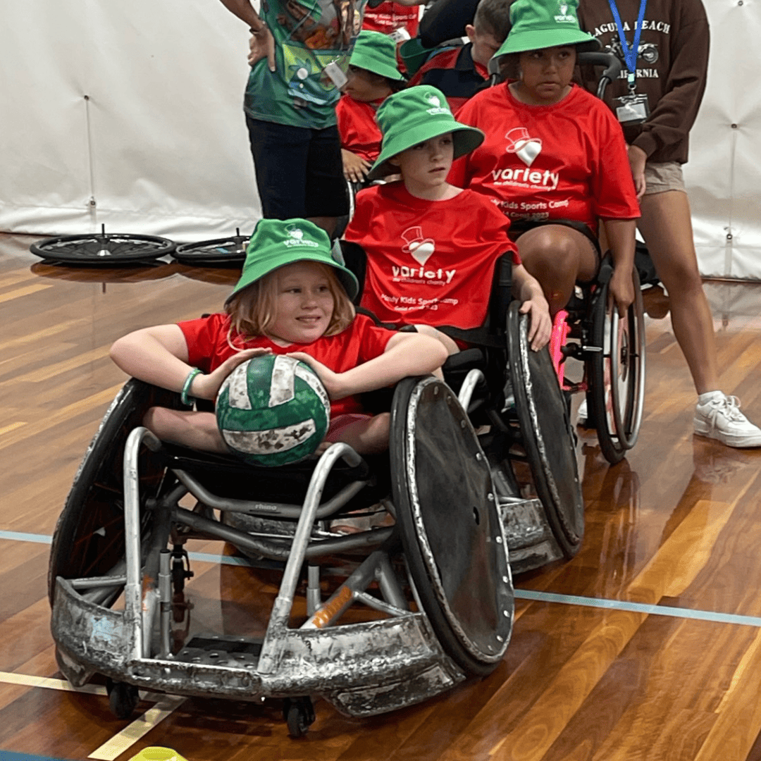 Variety group A young girl plays wheelchair basketball on the court.