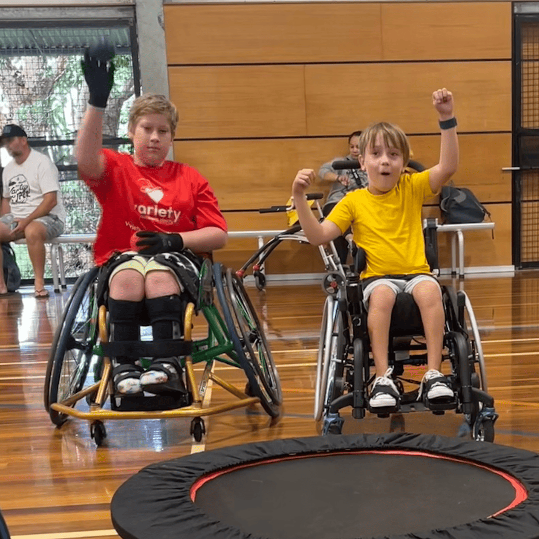 Variety kids happy A young girl plays wheelchair basketball on the court.