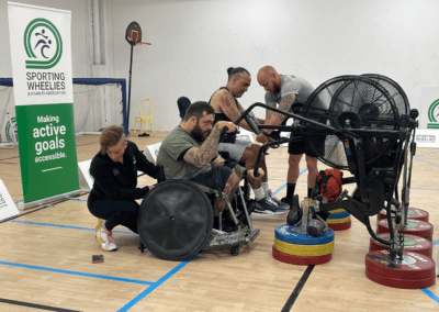 Two male wheelchair users working with an exercise physiologist during a group class to build fitness.