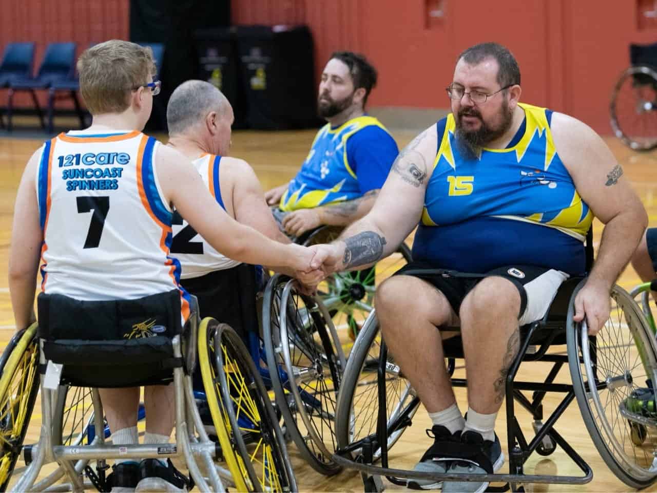 Two opposing teams shake hands on the court.