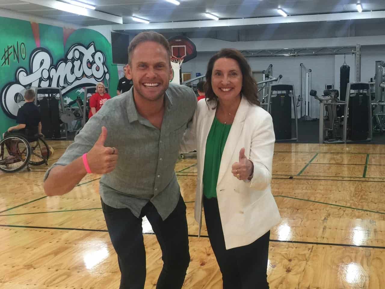 On the court, Sporting Wheelies CEO Amanda comes together for photo with a man.